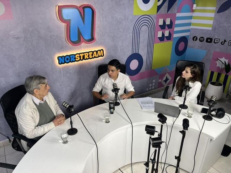 Entrevista en el set principal de Norstream: tres personas alrededor de la mesa curva con micrófonos y cámaras